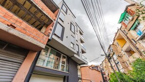 Un edificio moderno con techo plano, ventanas grandes y un balcón visible.