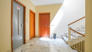 A hallway with a marble floor, wooden doors, and a staircase with a metal railing. - 2 bedroom nice apartment in Cavi di Lavagna (Cavi di Lavagna)