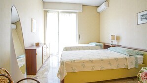 A hotel room with a bed, a desk, a chair, a mirror, and a window. - 2 bedroom nice apartment in Cavi di Lavagna (Cavi di Lavagna)