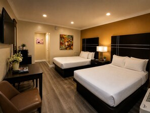 A hotel room with two beds, a desk, a chair, and a TV. - The Boards AC (Atlantic City)