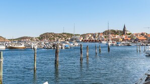 A marina with boats docked, a town with red-roofed buildings, and a church tower. - Fjällbacka by Interhome (Fjällbacka)