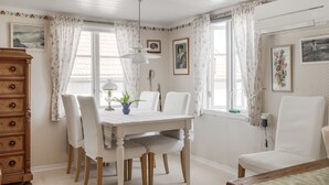 A dining area with a white table, chairs, and a wooden cabinet. - Fjällbacka by Interhome (Fjällbacka)