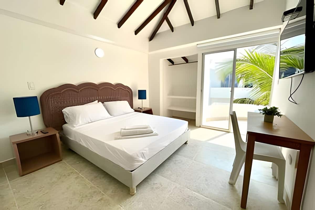Ein Schlafzimmer mit einem Bett, Nachttischen, einem Schreibtisch und einem Stuhl.