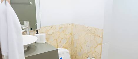 A bathroom with a white toilet, a sink, and a mirror.