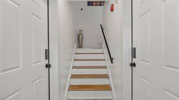 Eine Treppe mit weißen Wänden, einer Vase und einem Bild an der Wand.