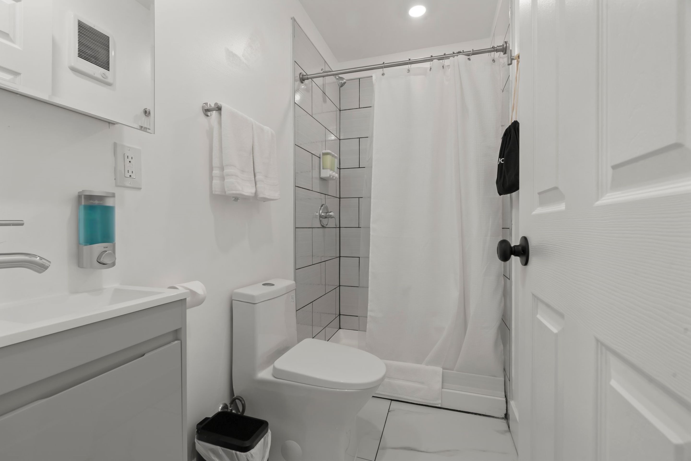 A modern bathroom with a toilet, sink, and shower area.