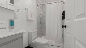 A modern bathroom with a toilet, sink, and shower area.