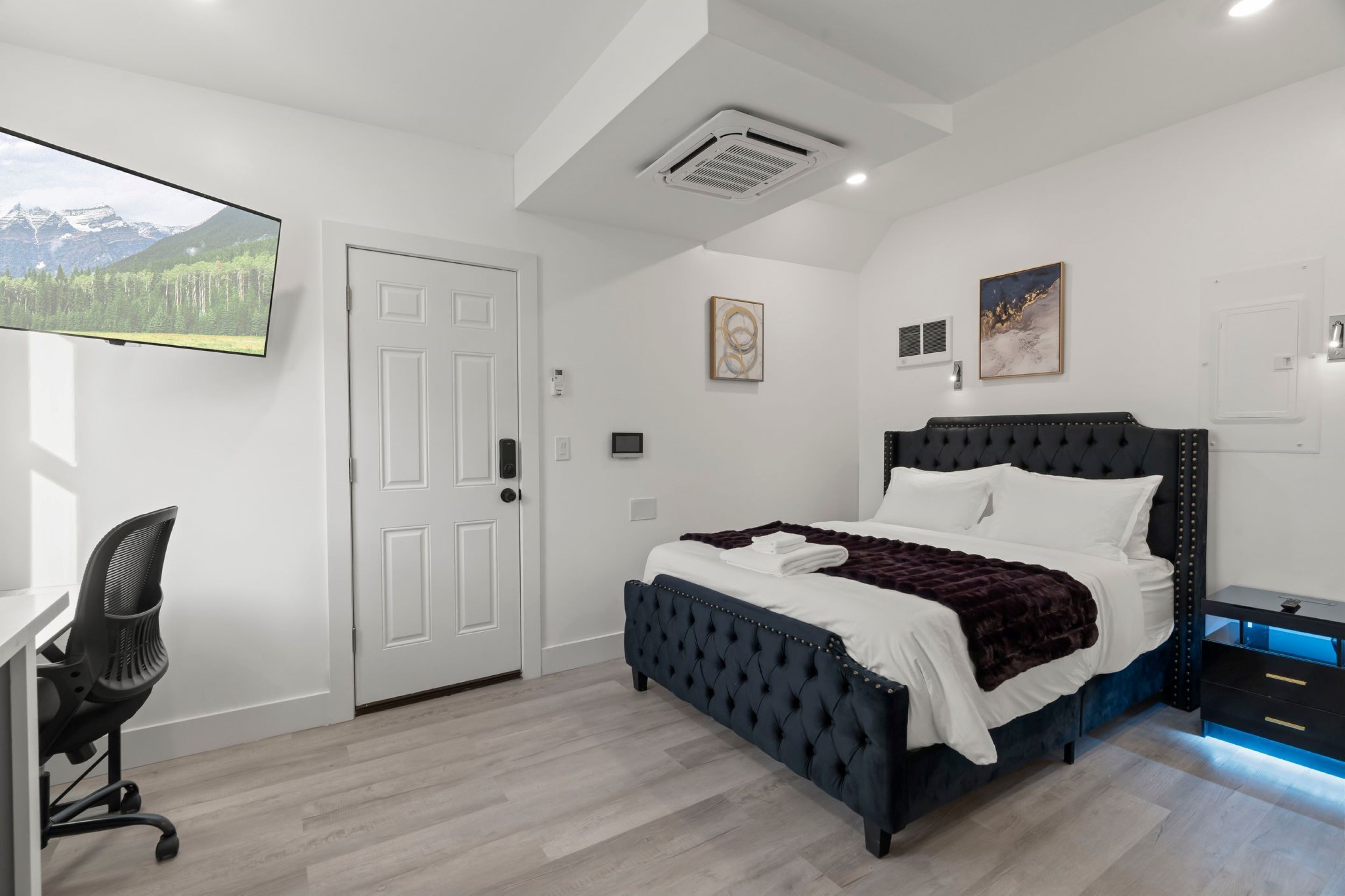 Un dormitorio con cama, escritorio y televisión.