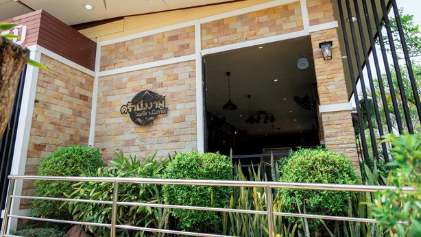 A building with a brick facade, a sign with Thai script, and a gated entrance. - Buengngarm Resort (Bung Khong Long)