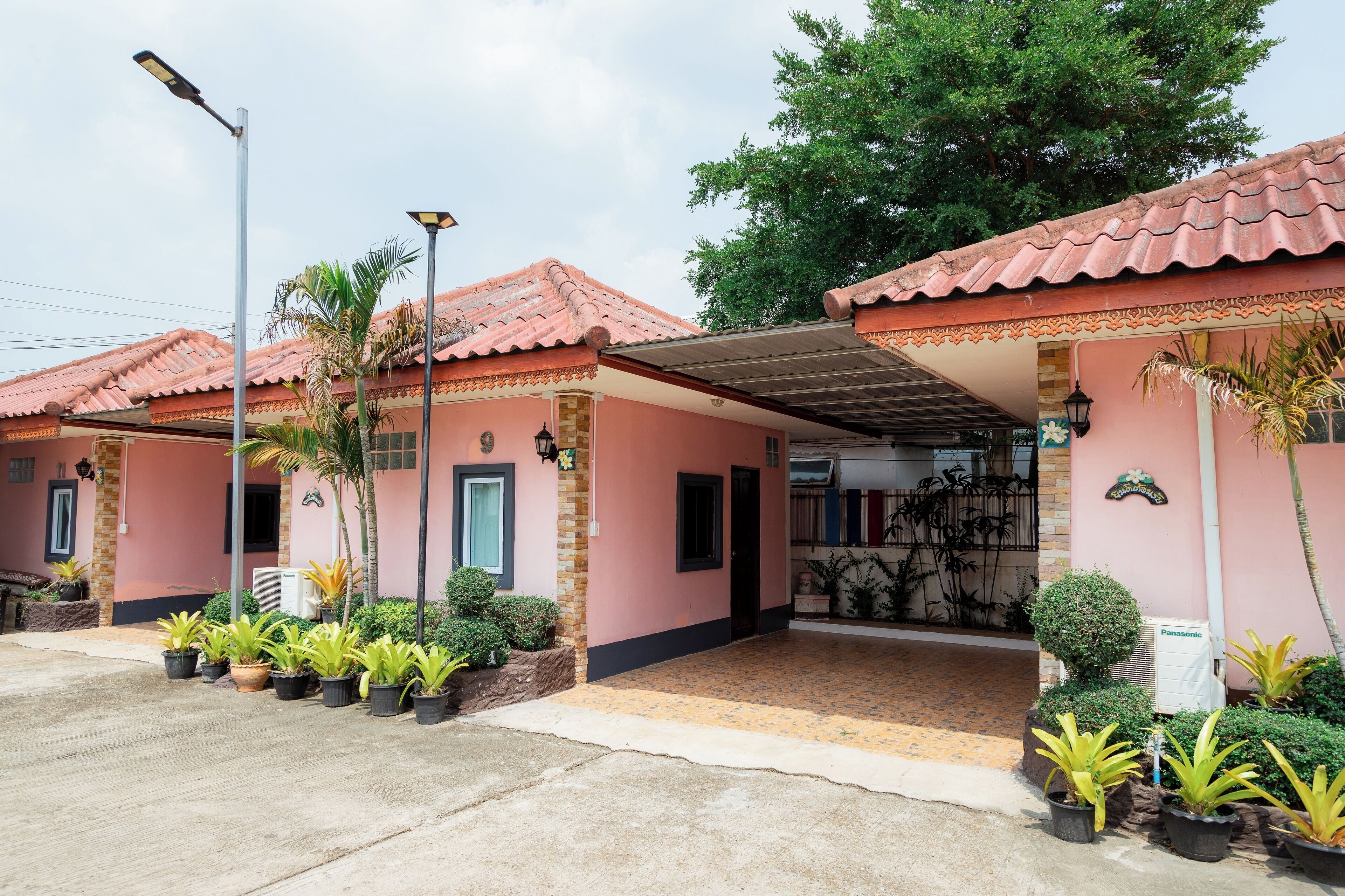 A building with a tiled roof, a covered entrance, and potted plants.