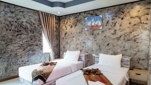 A hotel room with two beds, marble walls, a ship painting, and a window with curtains. - Buengngarm Resort (Bung Khong Long)