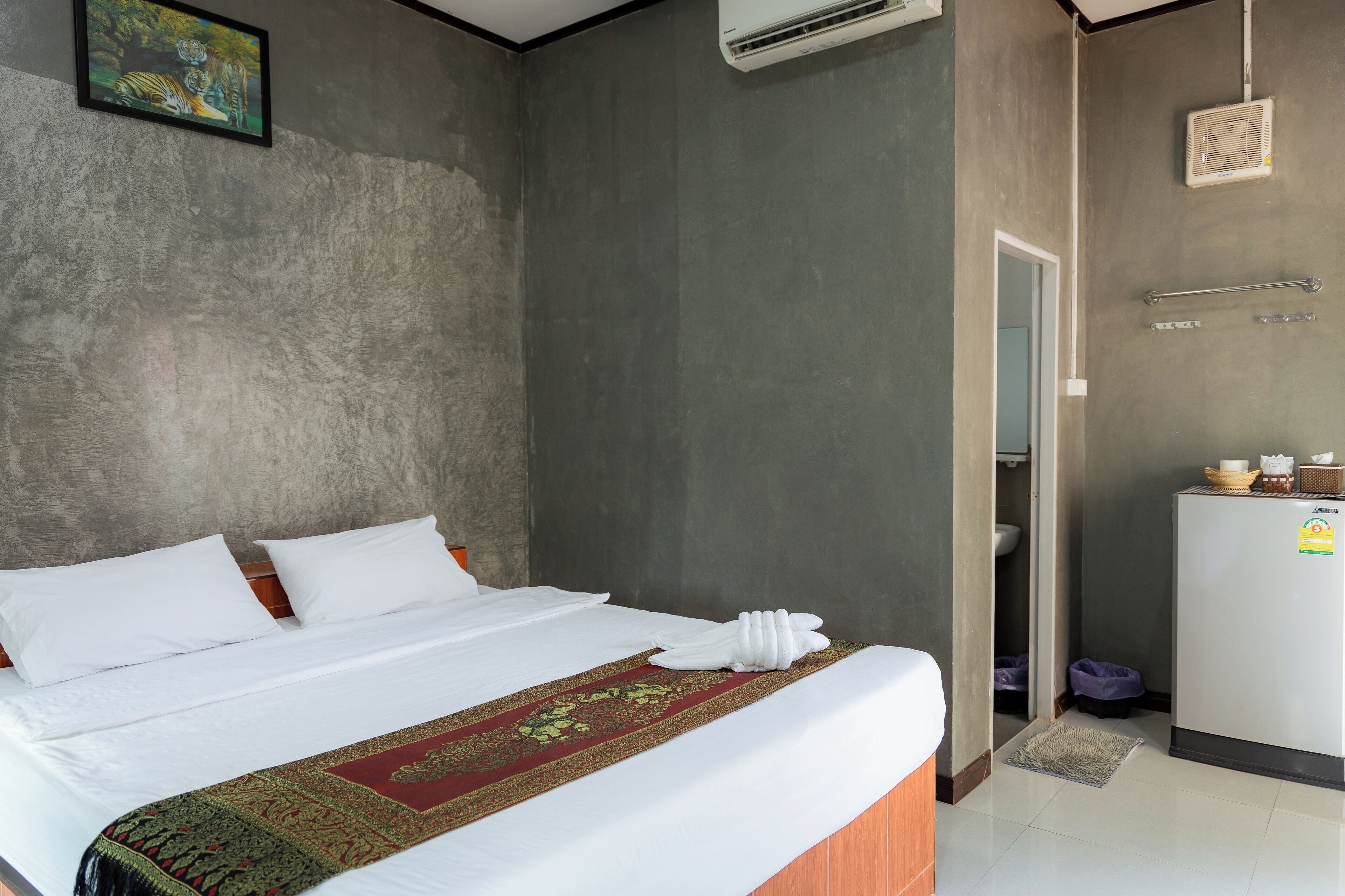 Een hotelkamer met een bed, een badkamer en een kitchenette.