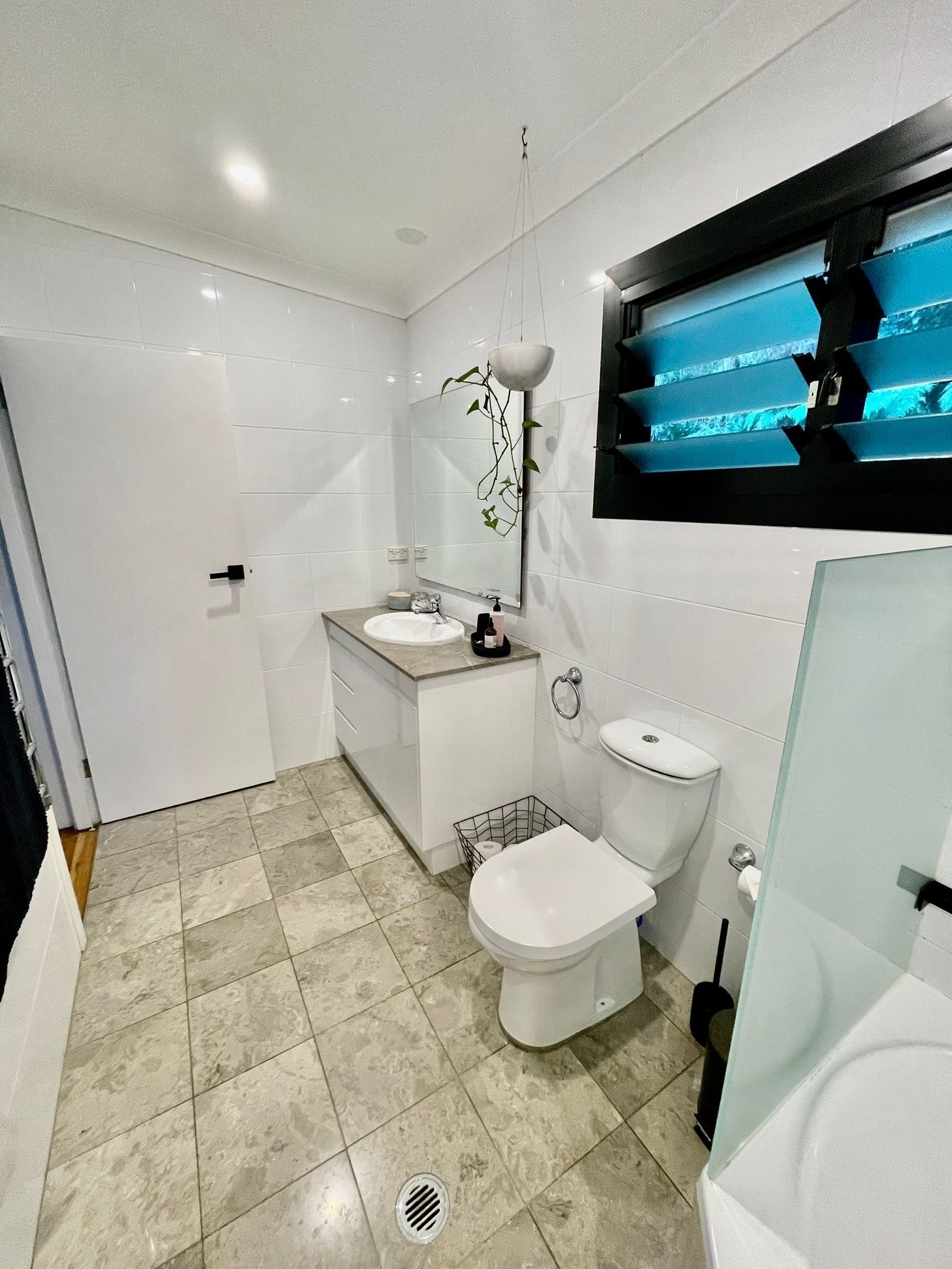 Ein modernes Badezimmer mit weißem Waschbecken, WC und Duschbereich.
