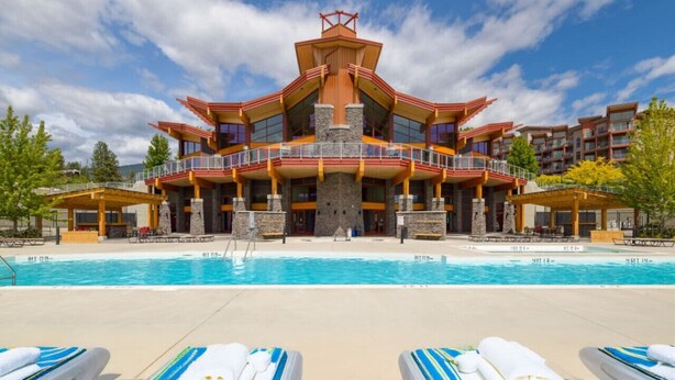 A resort with a large pool, multiple balconies, and a distinctive architectural design.