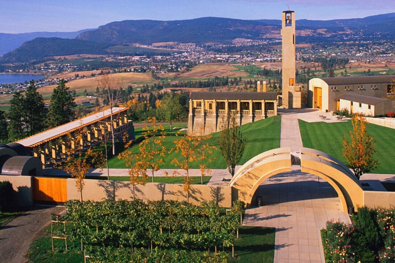 Un grand bâtiment doté d’une tour centrale, entouré d’une pelouse bien entretenue et d’un chemin piétonnier incurvé.