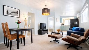 Een moderne woonkamer met een eethoek, een televisie en een bank.