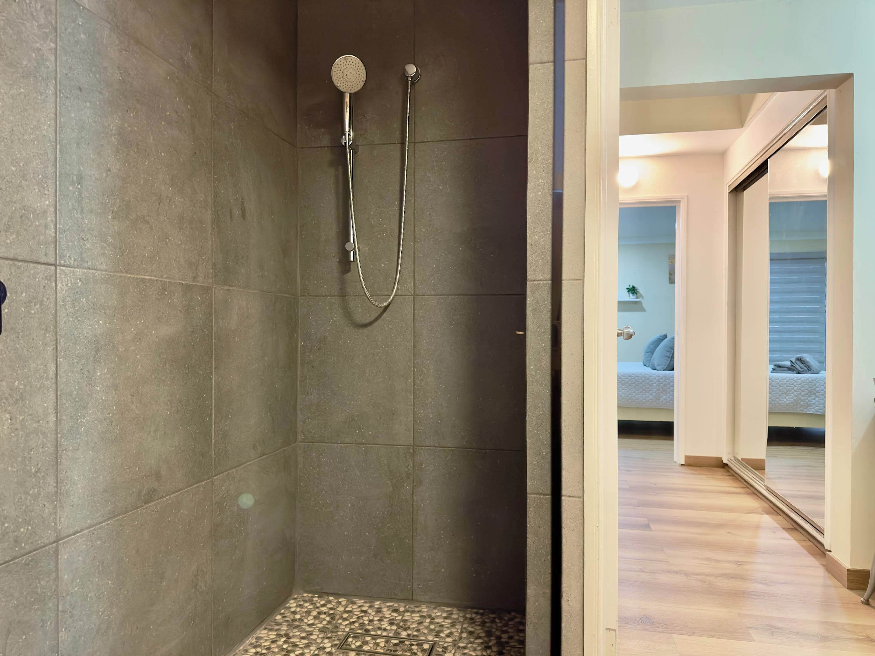 A shower with a tiled floor and a visible showerhead.