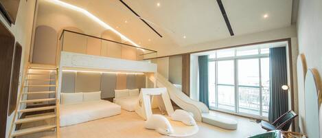 Una habitación moderna ideal para niños, con una cama litera, un tobogán y una zona de juegos.