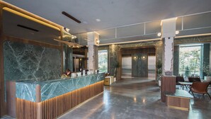 A modern hotel lobby with a marble reception desk, wooden accents, and a spacious layout. - PAPO'A HARBOR HOTEL (Kaohsiung)