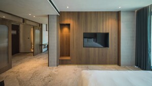 A modern hotel room with a large bed, a mounted TV, and a wooden accent wall. - PAPO'A HARBOR HOTEL (Kaohsiung)