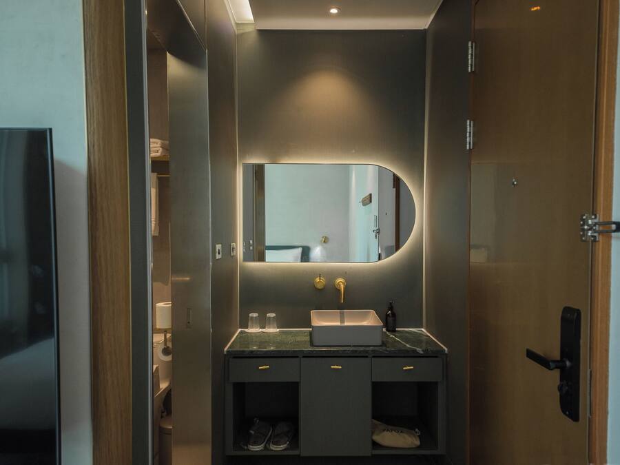 Un baño moderno con tocador, lavabo y espejo.