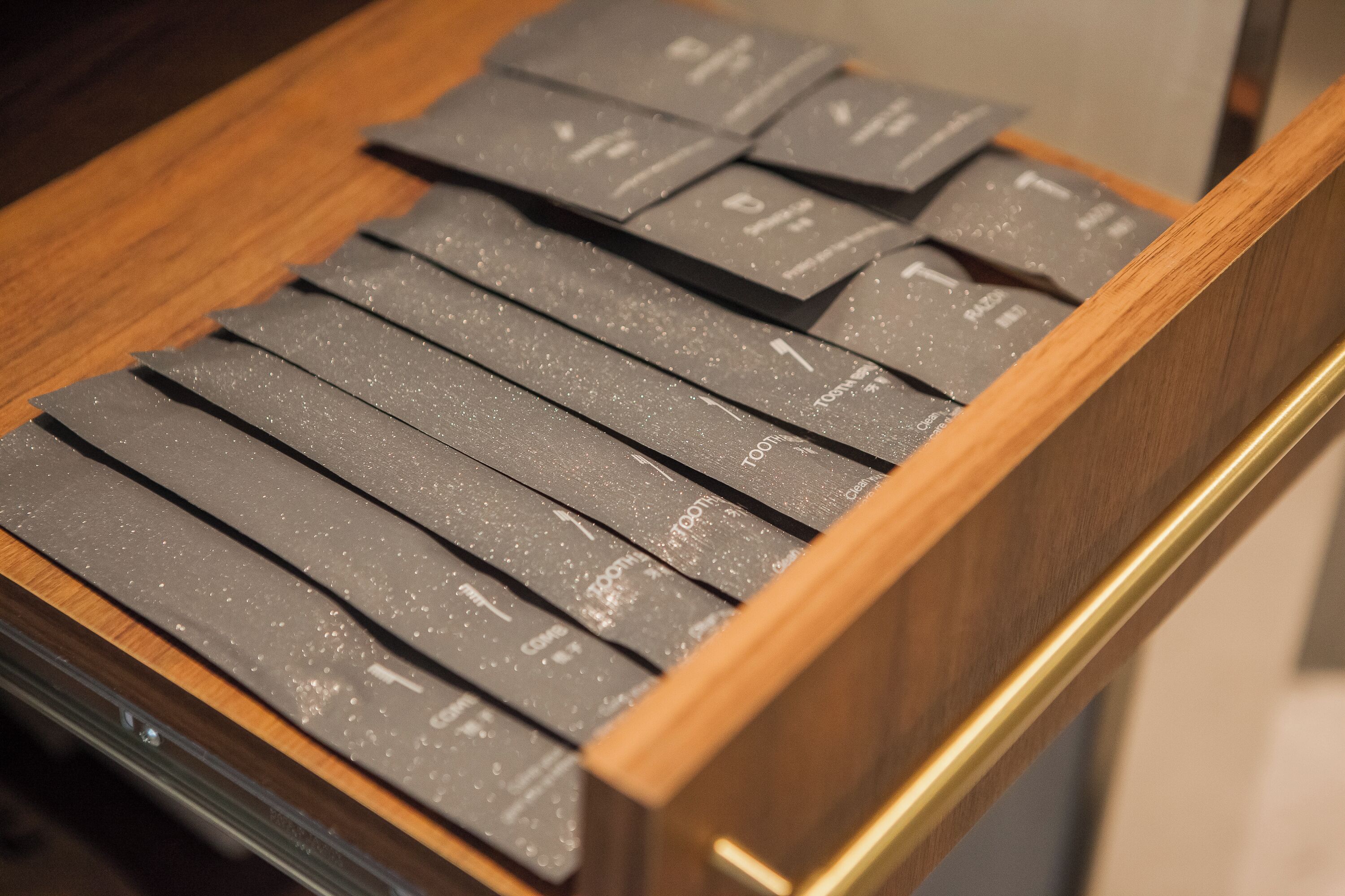 Un tiroir rempli d’objets noirs et rectangulaires, qui pourraient être des emballages ou des documents.