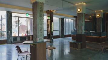 A spacious lobby with high ceilings, large windows, and a reception desk.
