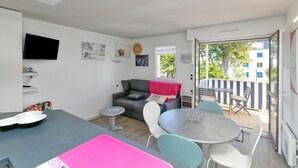 Ett modernt vardagsrum med en soffa, ett matbord och en tv.