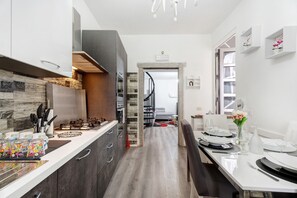 A modern kitchen with a central island, built-in appliances, and a dining area with a table set for four.