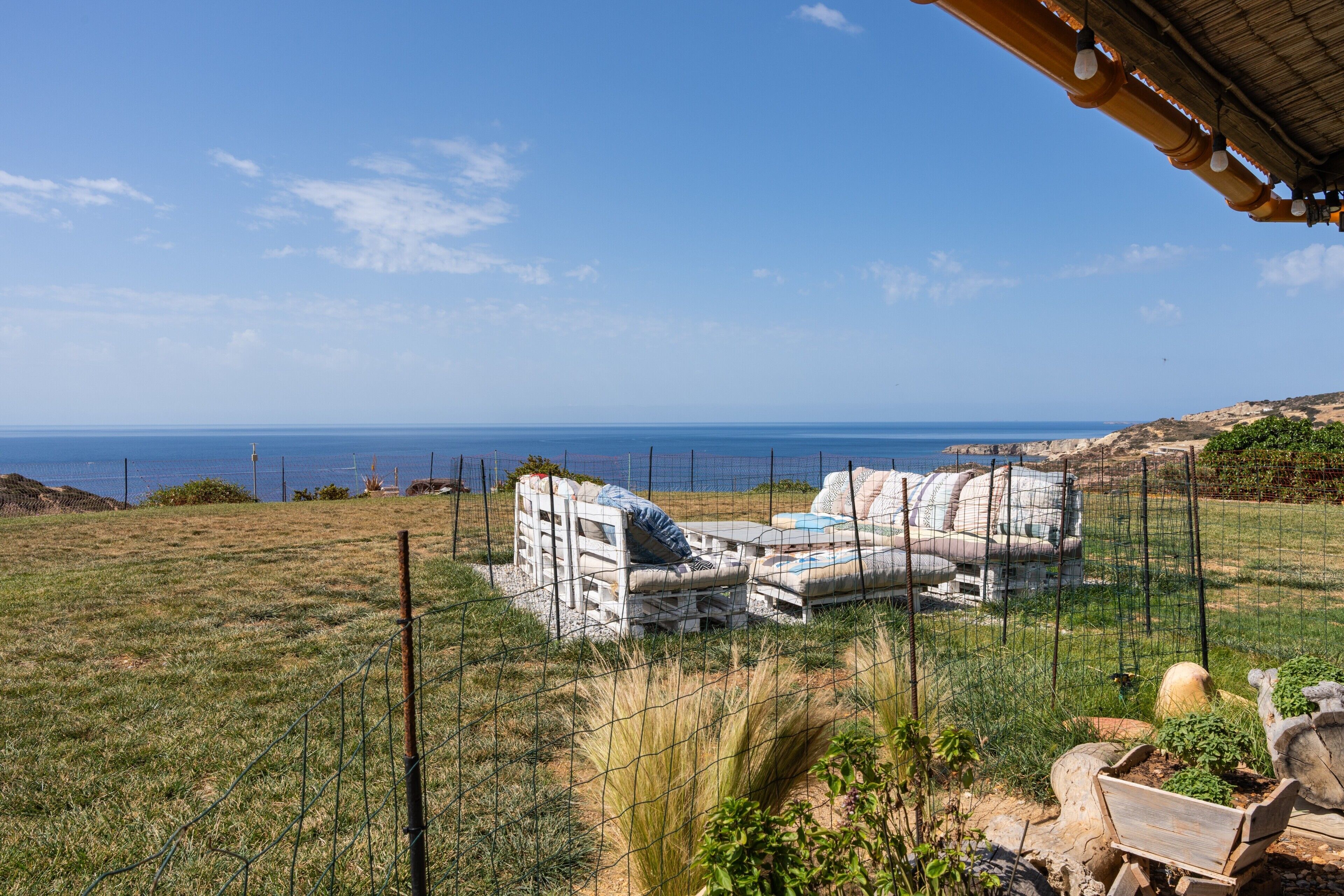 Une propriété située sur la côte, dotée d’un espace clôturé, d’un coin salon extérieur et offrant une vue sur la mer.