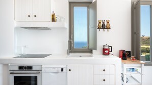Eine moderne Küche mit Geschirrspüler, Backofen und einem Fenster mit Meerblick.