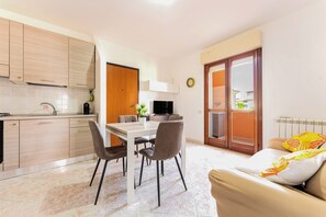 Une cuisine moderne avec un coin repas, un canapé et une vue sur l’extérieur.