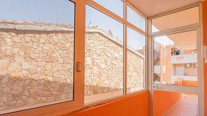 A room with a stone wall, a large window, and an orange interior.