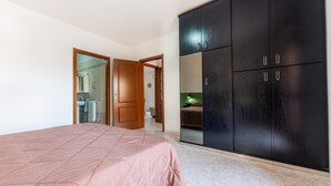 A bedroom with a bed, wardrobe, and a bathroom visible through an open door.