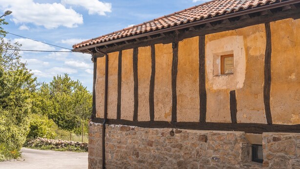 Ein Gebäude aus Stein mit einem Ziegeldach und einem kleinen Fenster.