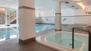 A hotel indoor pool area with a hot tub, lounge chairs, and a staircase leading outside. - Apartment 'Bergerhof 3' with Mountain View, Shared Garden and Wi-Fi (Sarentino)