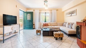 A living room with a television, sofa, coffee table, and a green door.