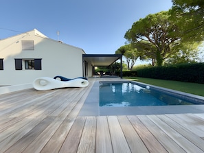 A modern house with a swimming pool, wooden deck, and a covered outdoor seating area. - Seaside Villa with Pool and Jacuzzi (Hyères)