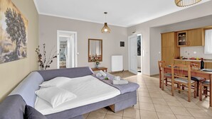 A modern bedroom with a bed, a dining area, and a kitchen. - Apartment 'Elaia  2' with Sea View, Wi-Fi and Air Conditioning (?e???da)