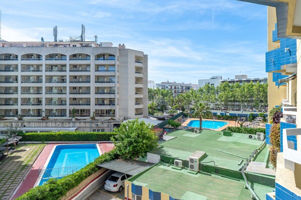 A multi-story hotel with a rooftop pool and a separate swimming pool area.