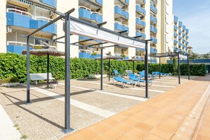 A resort with outdoor seating, a pool area, and a building with balconies.