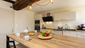 Eine moderne Küche mit einer Holztheke, weißen Schränken, einer Mikrowelle und einem großen Fenster.