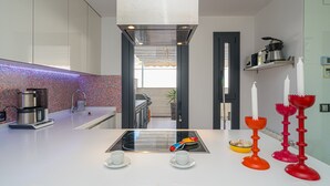 Une cuisine moderne dotée d’un îlot central, d’une machine à café et donnant sur la salle à manger.