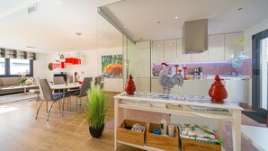 Un salon moderne comprenant un coin repas, une cuisine et une grande fenêtre.