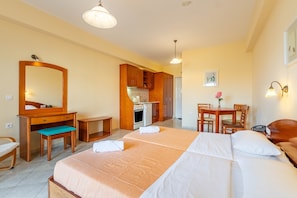 Une chambre d’hôtel équipée d’un lit, d’un bureau, d’une chaise et d’une kitchenette.