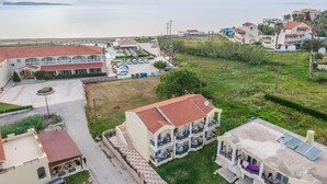 Un hôtel situé sur la côte, doté de nombreux balcons, d’un parking et offrant une vue sur la mer.