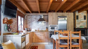 A modern kitchen with wooden cabinets, a built-in oven, microwave, and a large refrigerator.