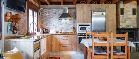 Une cuisine moderne avec des meubles en bois, un four encastré, un four à micro-ondes et un grand réfrigérateur.