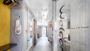A hallway with a shoe rack, a glass wall with text, and a view into a dining area. - Apartment 'Maison De La Musique' with Mountain View, Shared Terrace and Wi-Fi (Cogne)