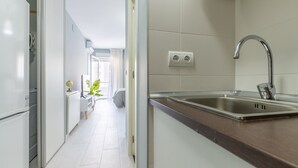 A modern kitchen with a stainless steel sink, a built-in oven, and a window overlooking a balcony. - Studio Apartment 'Torremolinos Dream Sea Views' with Sea View, Wi-Fi & Air Conditioning. (Torremolinos)